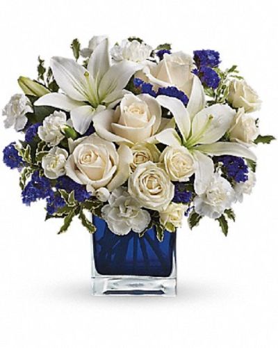 <div class="m-pdp-tabs-description">
<div id="mark-1" class="m-pdp-tabs-marketing-description">Send someone a bit of heaven with this beautiful bouquet. Luxurious crème roses and pure white lilies paint a peaceful picture inside a blue cube.</div>
</div>
Crème roses, white asiatic lilies and white miniature carnations are mixed with bursts of purple statice and green pitta negra. Delivered in a glass cube.
<ul>
<li>Our florists hand-design each arrangement, so colors, varieties and container may vary due to local availability</li>
</ul>