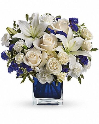 <div class="m-pdp-tabs-description">
<div id="mark-1" class="m-pdp-tabs-marketing-description">Send someone a bit of heaven with this beautiful bouquet. Luxurious crème roses and pure white lilies paint a peaceful picture inside a blue cube.</div>
</div>
Crème roses, white asiatic lilies and white miniature carnations are mixed with bursts of purple statice and green pitta negra. Delivered in a glass cube.
<ul>
<li>Our florists hand-design each arrangement, so colors, varieties and container may vary due to local availability</li>
</ul>